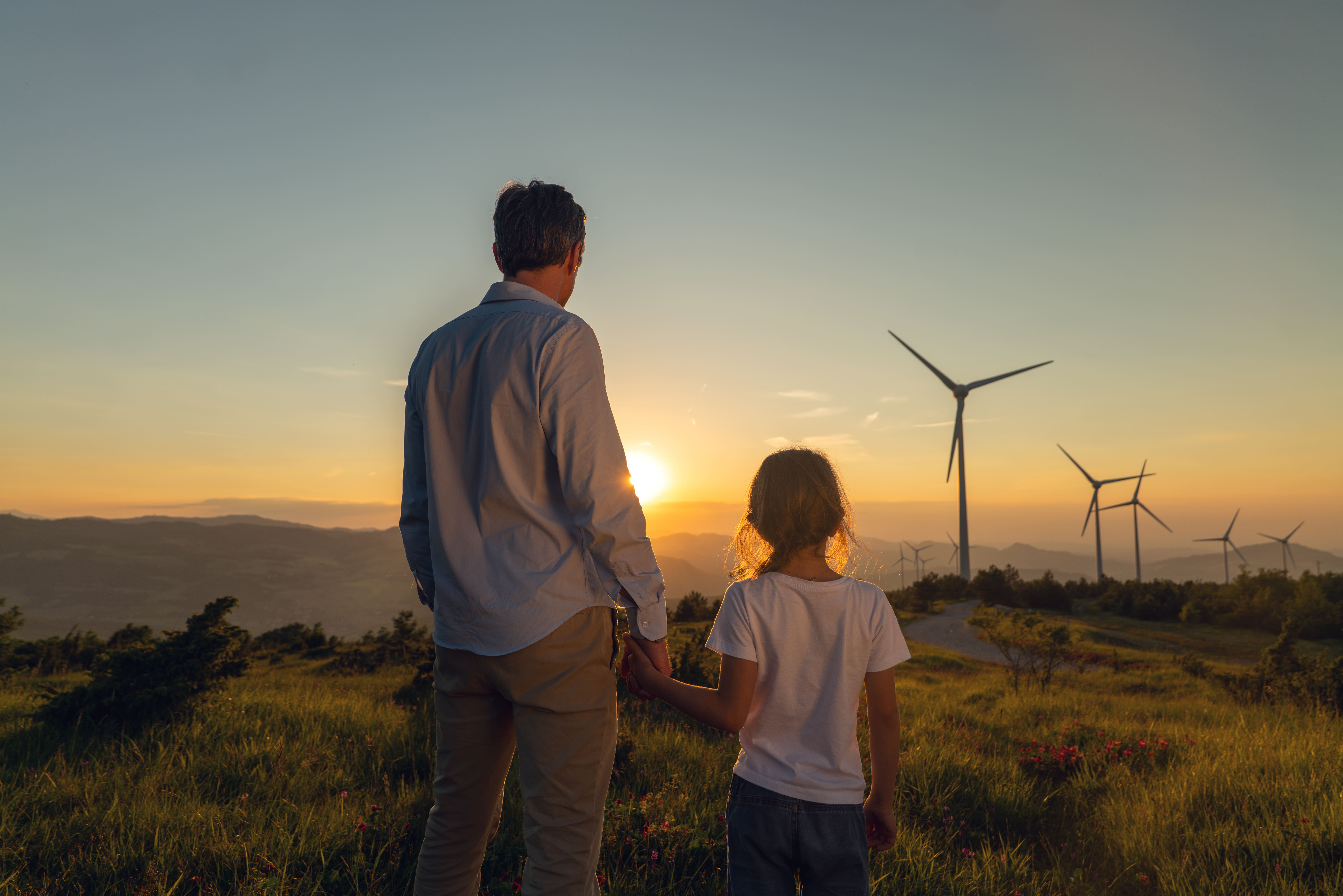 Man and child overlooking a wind farm