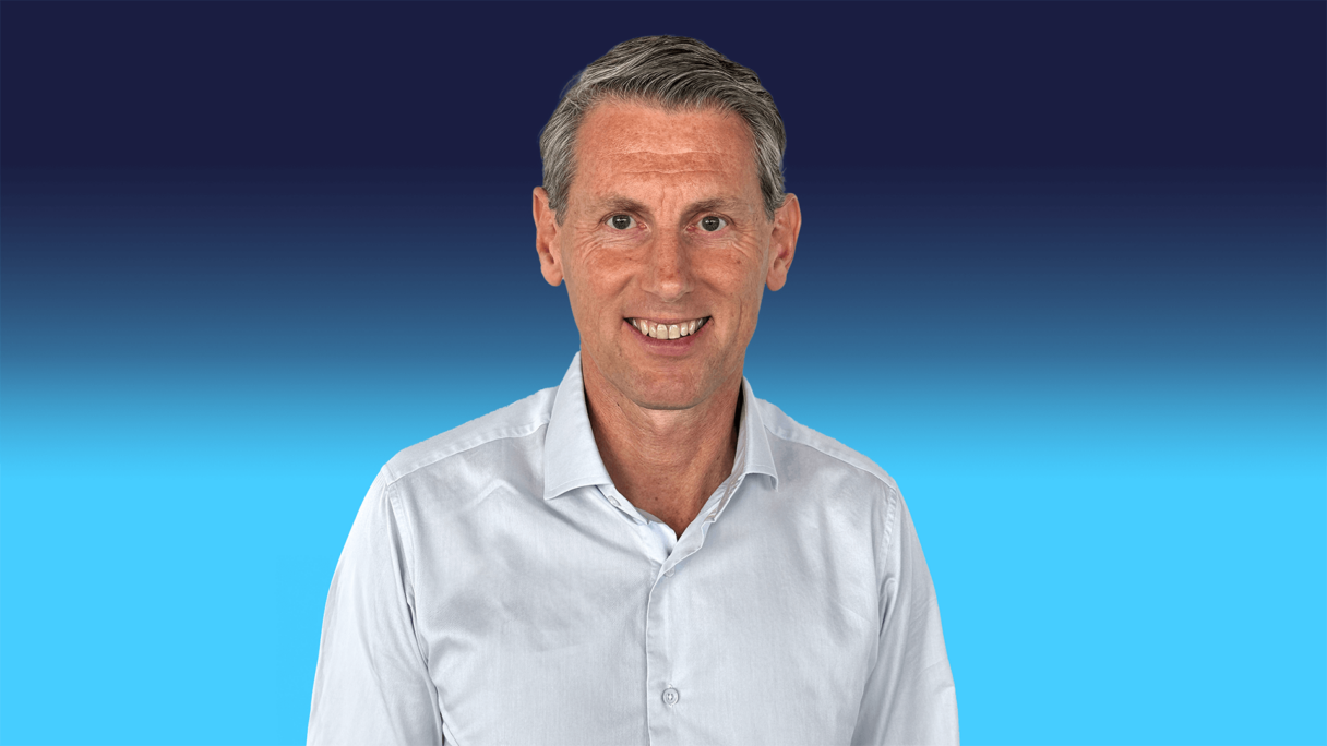 Lieven Debruyn headshot Executive Vice chair wearing a blue shirt on a blue background